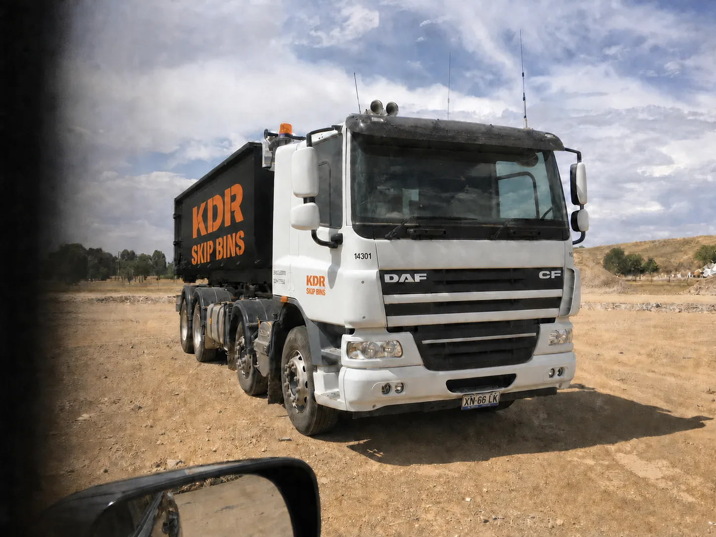 A KDR Skip Bins hook-lift truck loaded with a skip bin, ready for delivery